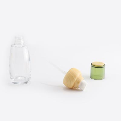 прозрачная косметическая стеклянная бутылка с бамбуковой крышкой
