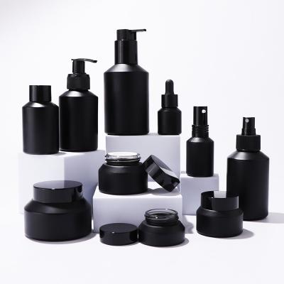 Черные матовые стеклянные бутылки и банки для упаковки средств по уходу за кожей